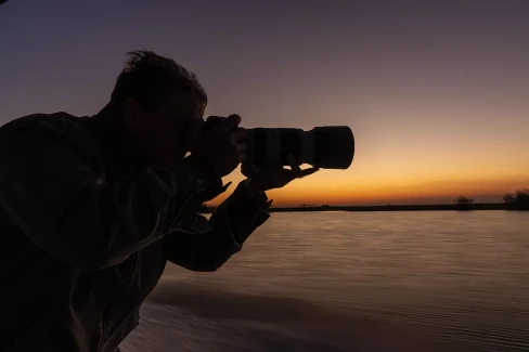 Photographer at work in the foreground of a sunset